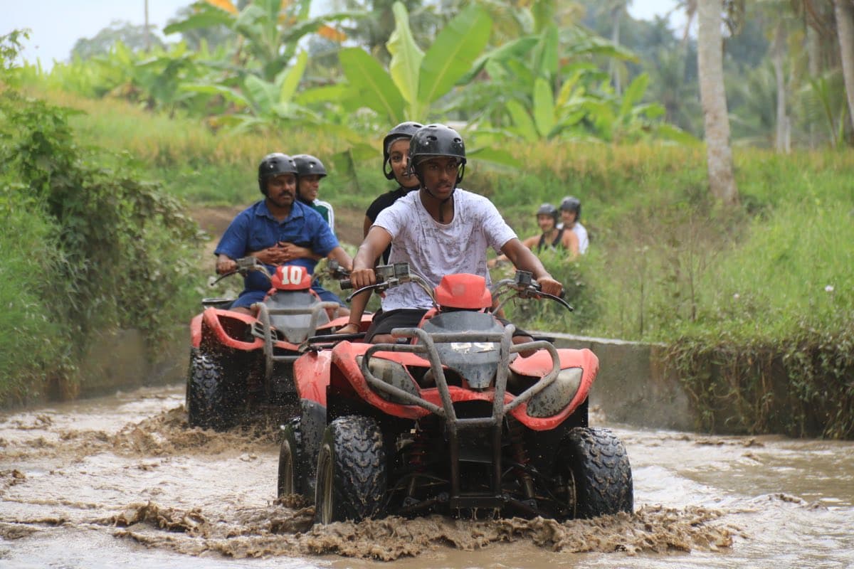 Group of ATVs powering through a muddy river