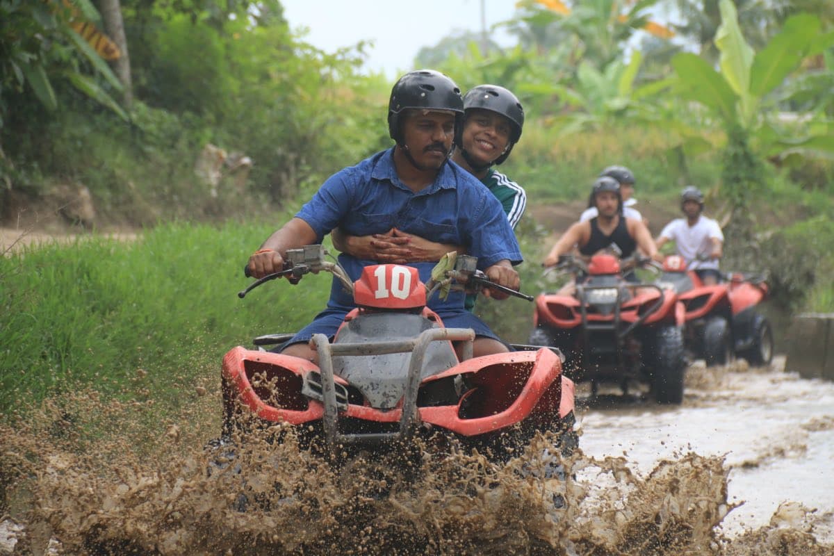 Convoy of ATVs crossing a shallow river in the jungle