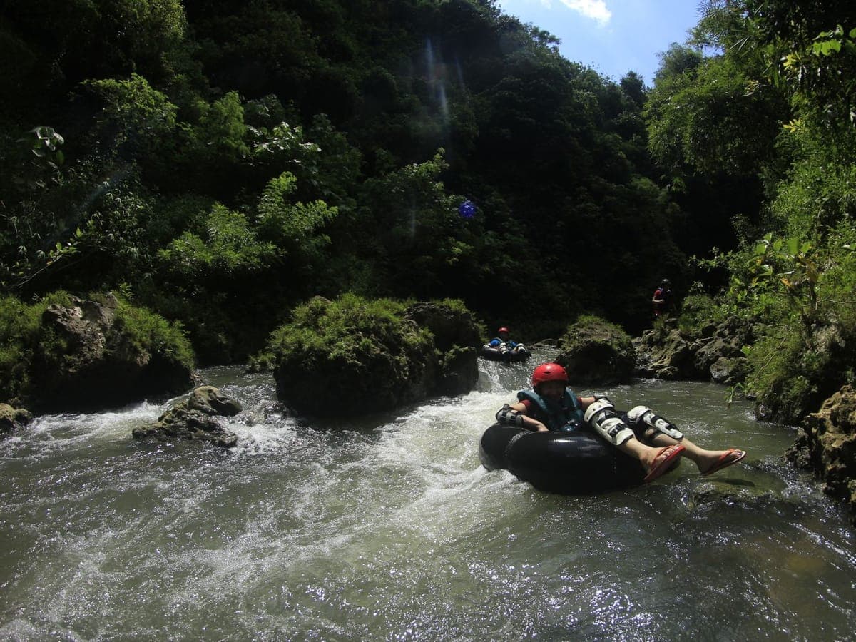 A rider floating down jungle rapids on a tube in Ubud