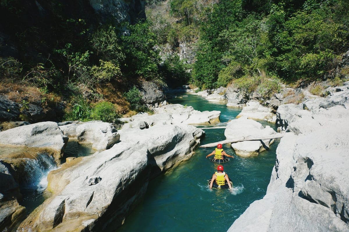 Tubers drifting through a green river gorge