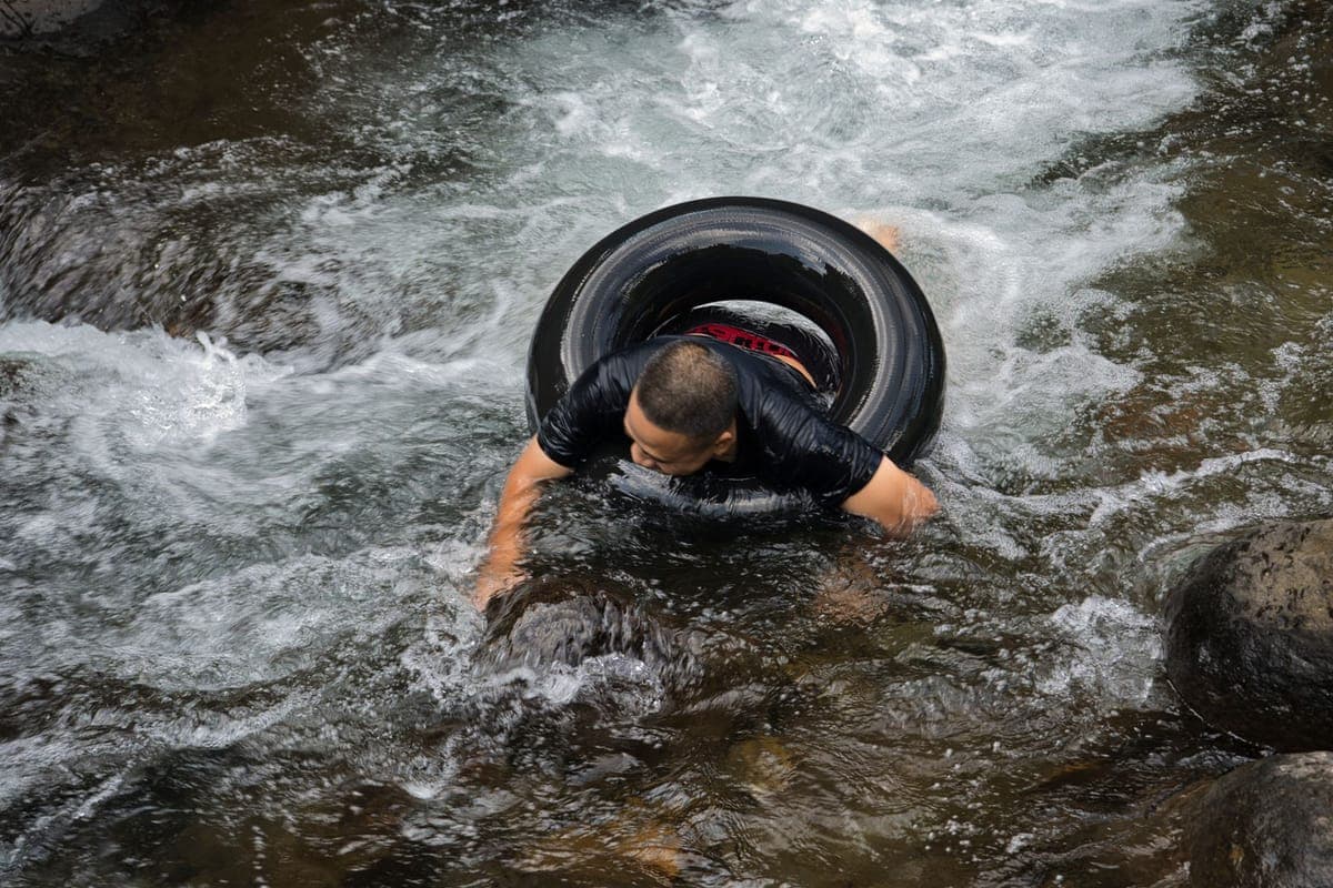 Close-up of a guide steering a tube down a small rapid