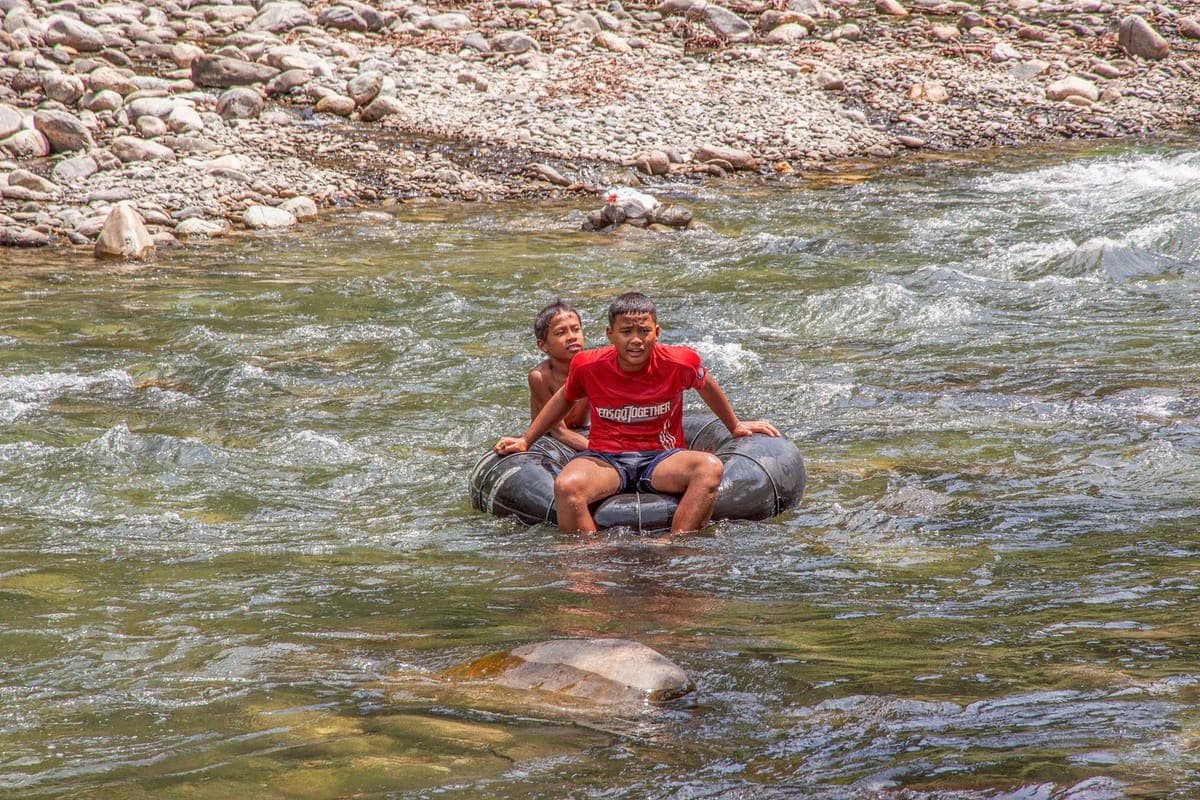 Group of friends laughing while river tubing
