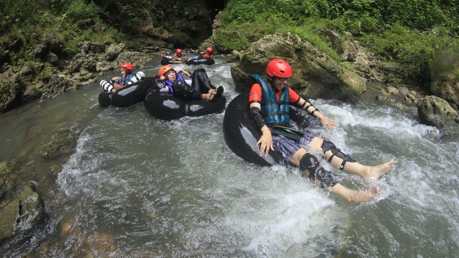 A rider floating down jungle rapids on a tube in Ubud